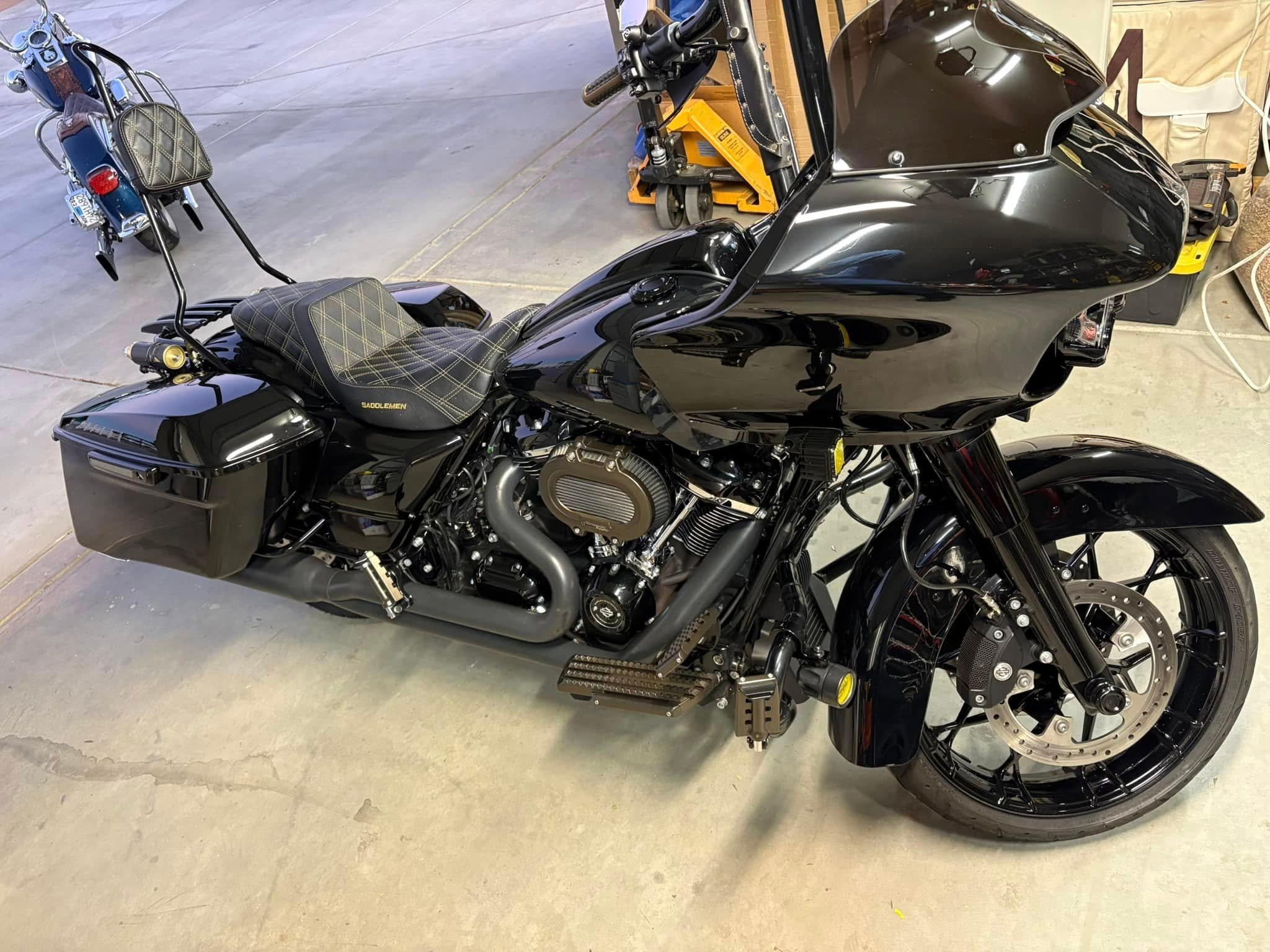 Black motorcycle with quilted seat and saddlebags in workshop