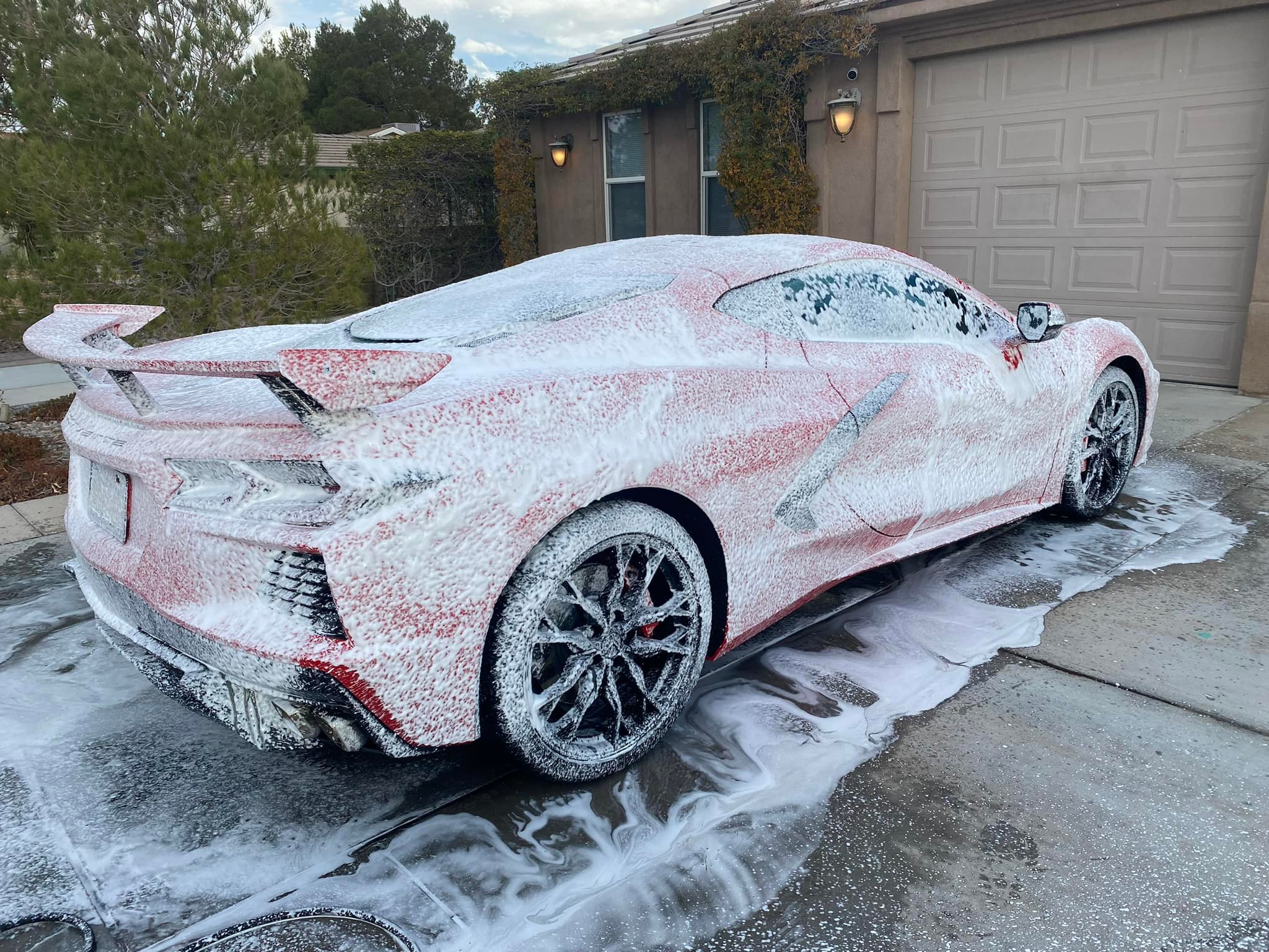 Sports car covered in frost and snow, parked in residential driveway