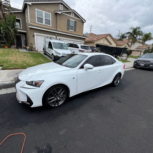 White Lexus sedan parked on residential street with other vehicles