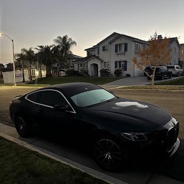 Black sports car parked on suburban street at sunset